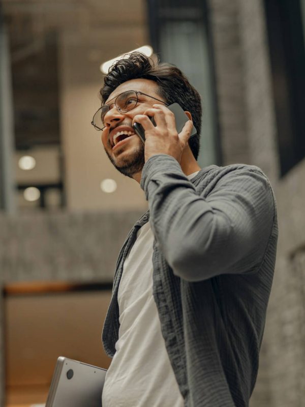 stylish-businessman-in-eyeglasses-is-talking-phone-standing-in-modern-coworking-space.jpg